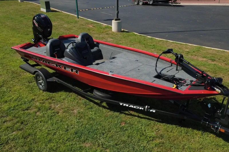 Slide: The Image of 2026 Tracker Pro Team 190 boat on trailer, red exterior, parked on grass. - 7