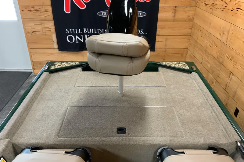 Slide: The Image of 2026 Tracker Bass Tracker Classic Limited boat interior with beige seating and carpeted deck. - 5