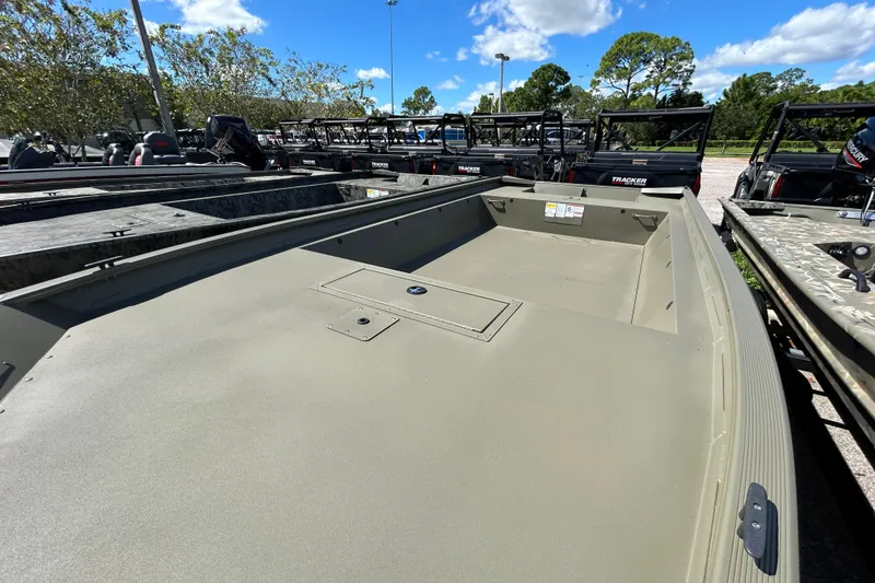 Slide: The Image of 2026 Tracker Grizzly 1860 Utility boat in outdoor showroom under blue sky. - 2