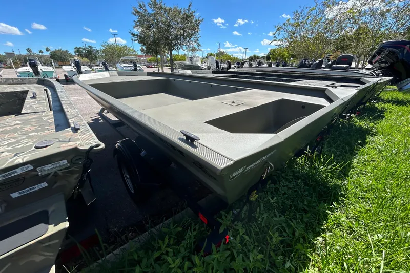 Slide: The Image of 2026 Tracker Grizzly 1860 Utility boat on trailer, parked outdoors under clear blue sky. - 3