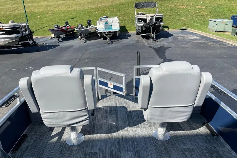 Slide: The Image of 2024 Ranger Reata 220F pontoon boat on trailer, parked outdoors with scenic background. - 3