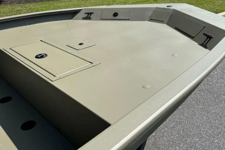 Slide: The Image of 2026 Tracker Grizzly 1860 CC boat deck with storage compartments, shown outdoors. - 10