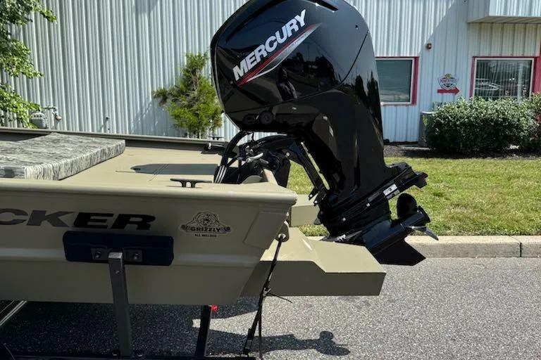 Slide: The Image of 2026 Tracker Grizzly 1860 CC boat with Mercury outboard motor, parked outdoors. - 3