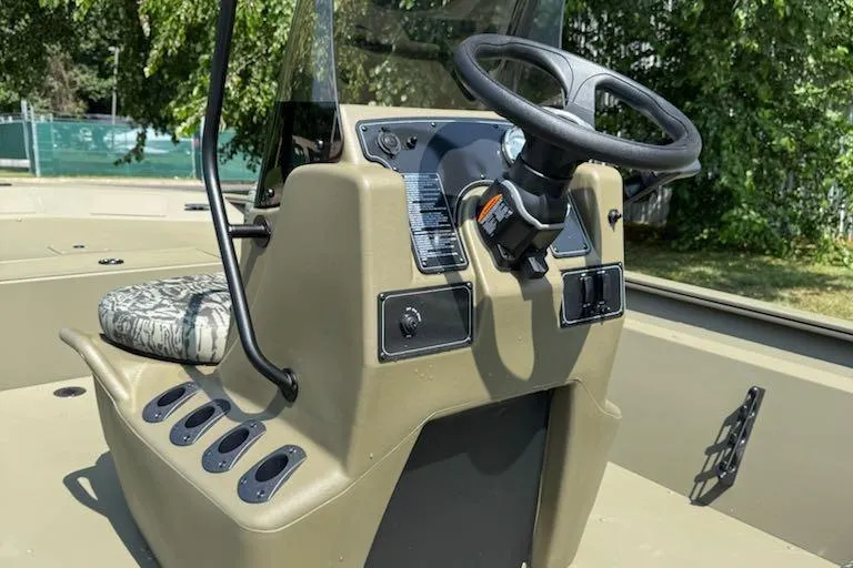 Slide: The Image of 2026 Tracker Grizzly 1860 CC boat console with steering wheel and controls. - 7