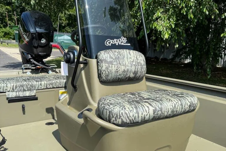Slide: The Image of 2026 Tracker Grizzly 1860 CC boat with camo seating and outboard motor. - 8