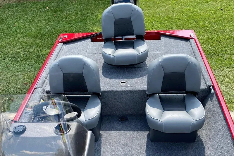 Slide: The Image of 2026 Tracker Bass Tracker Classic XL boat interior with three gray seats on a red deck. - 6