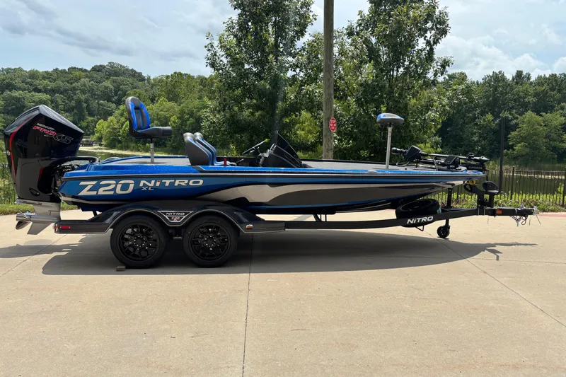 The Image of 2026 Nitro Z20 XL Pro boat on trailer, parked outdoors with trees in background. - 0
