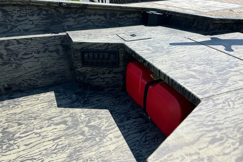 Slide: The Image of 2026 Tracker Grizzly 1650 T Prairie Wings Edition boat interior with camouflage design and red fuel tank. - 10