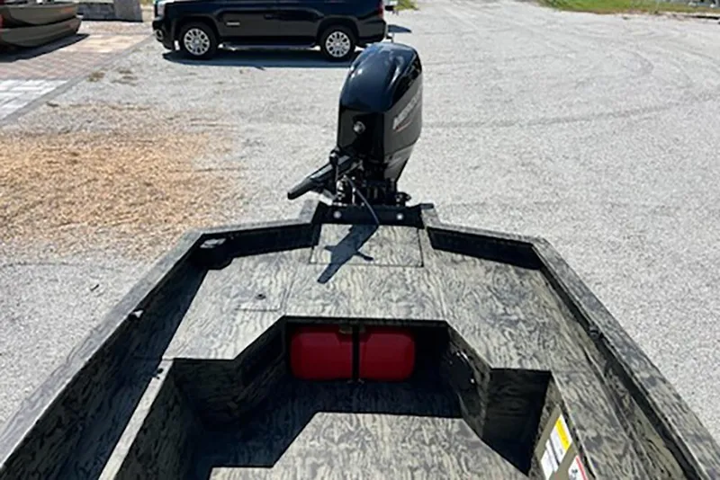 Slide: The Image of 2026 Tracker Grizzly 1650 T Prairie Wings Edition boat with outboard motor in parking lot. - 7