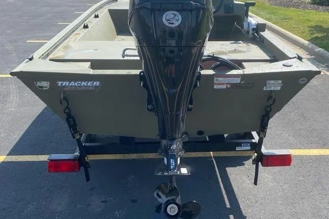 Slide: The Image of 2026 Tracker Grizzly 1648 SC boat with outboard motor, parked on a trailer. - 3