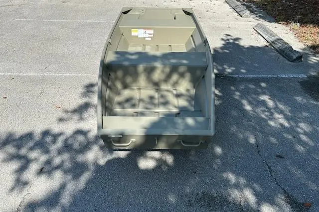 Slide: The Image of 2026 Tracker Grizzly 14 Jon boat in a parking lot, shadowed by trees. - 2