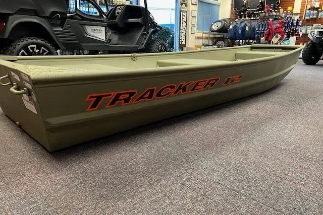 Slide: The Image of 2026 Tracker Grizzly 12 Jon boat displayed indoors, featuring durable design and olive green color. - 39