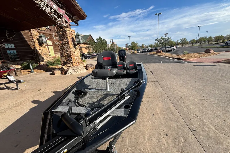 Slide: The Image of 2026 Tracker Pro Team 175 Crappie Edition boat parked outside a rustic building. - 16