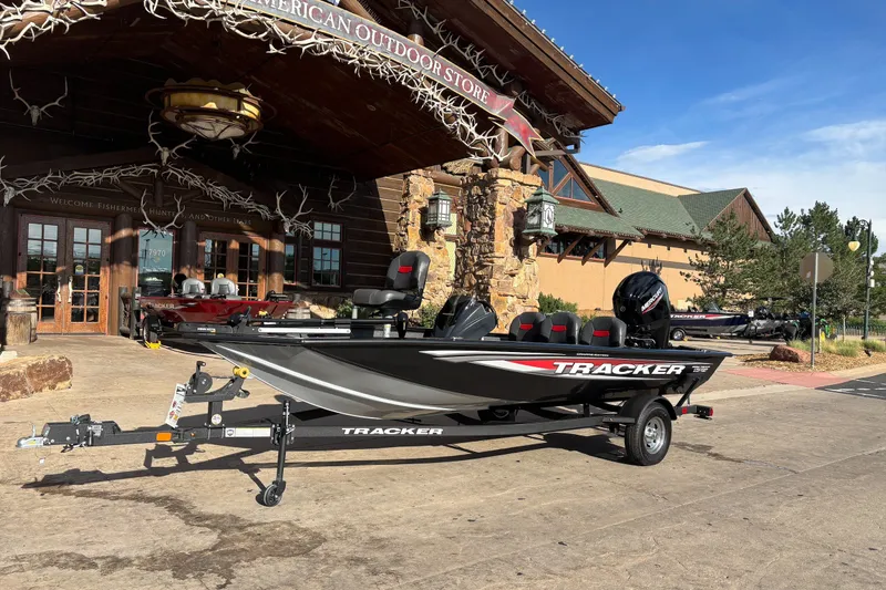 Slide: The Image of 2026 Tracker Pro Team 175 Crappie Edition boat displayed outside a rustic outdoor store. - 13