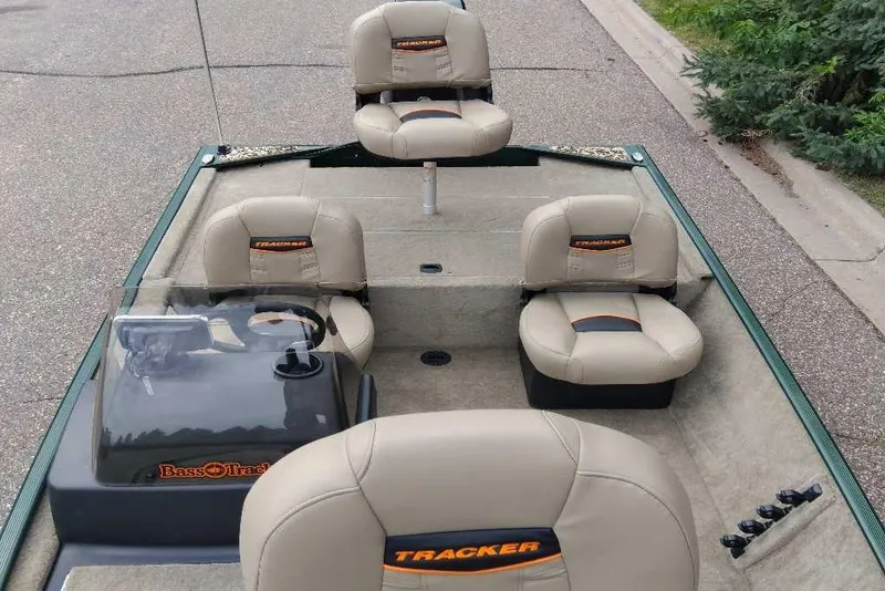 Slide: The Image of 2026 Tracker Bass Tracker Classic Limited boat interior with beige seating and steering console. - 3