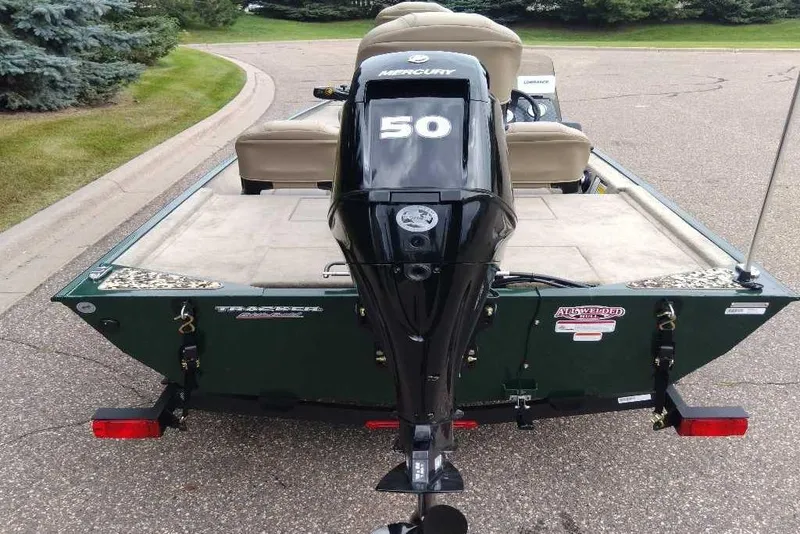 Slide: The Image of 2026 Tracker Bass Tracker Classic Limited boat with Mercury 50 engine, parked on a road. - 7
