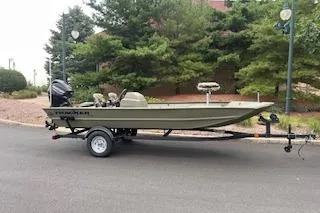 The Image of 2026 Tracker Grizzly 1754 SC boat on trailer, parked outdoors near trees. - 0