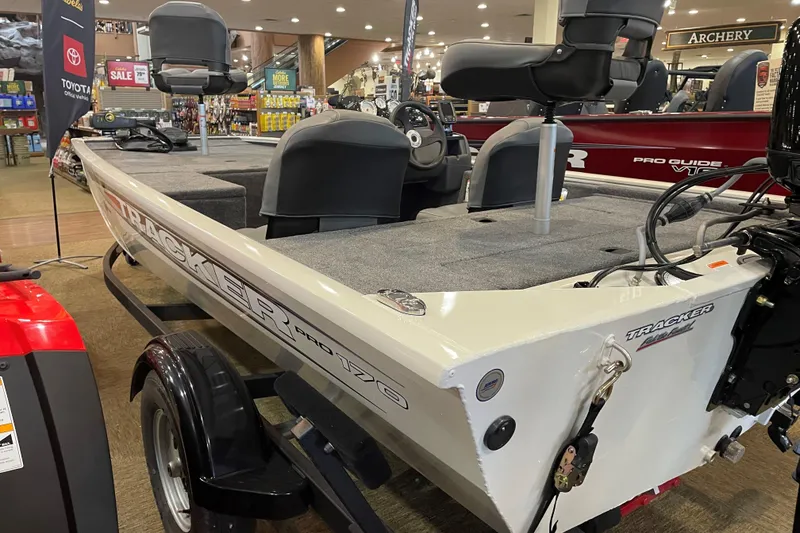 The Image of 2026 Tracker Pro 170 boat displayed indoors, featuring seating and steering console. - 0