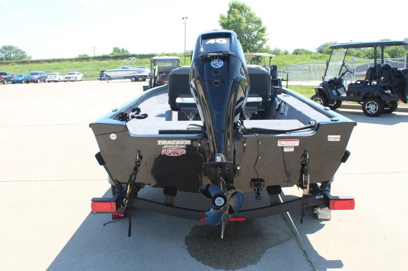 Slide: The Image of 2026 Tracker Super Guide V-16 SC boat with outboard motor, parked outdoors. - 6