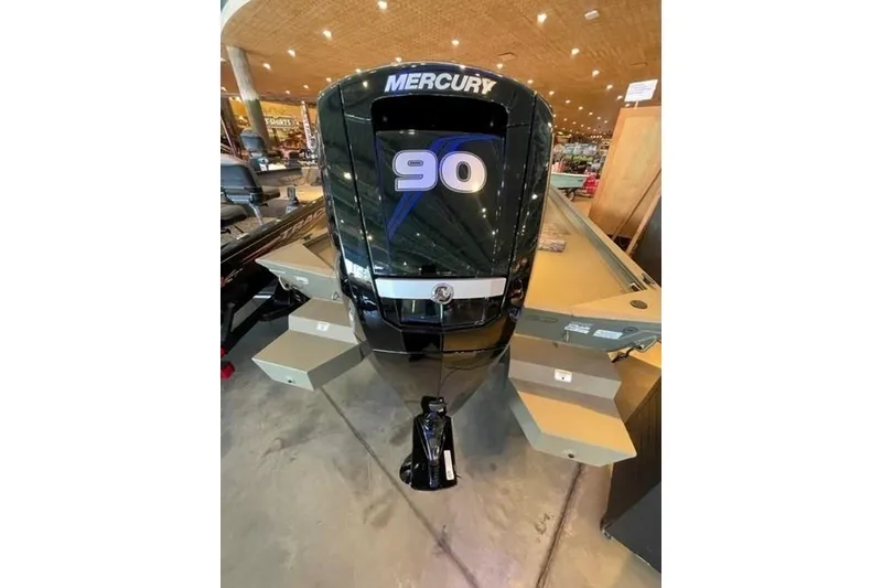 Slide: The Image of 2026 Tracker Grizzly 1860 CC boat with Mercury 90 engine displayed indoors. - 2