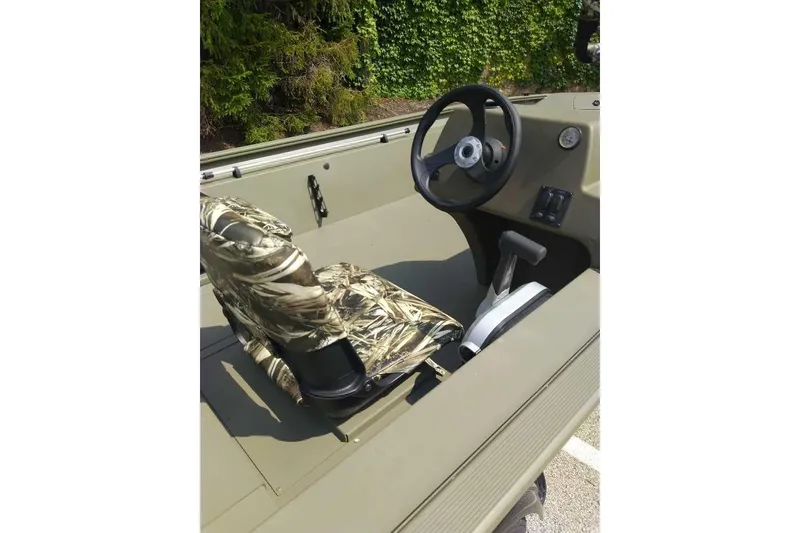 Slide: The Image of 2026 Tracker Grizzly 1754 SC boat interior with camo seat and steering wheel. - 2