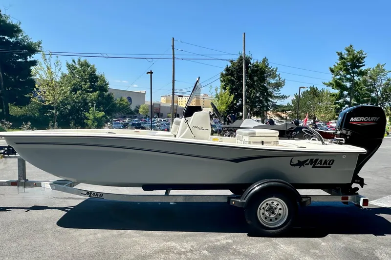 Slide: The Image of 2026 Mako Pro Skiff 15 CC boat on trailer, outdoors, with Mercury engine. - 1