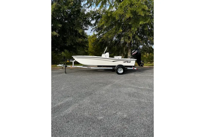 Slide: The Image of 2026 Mako Pro Skiff 15 CC boat on trailer, parked outdoors. - 2