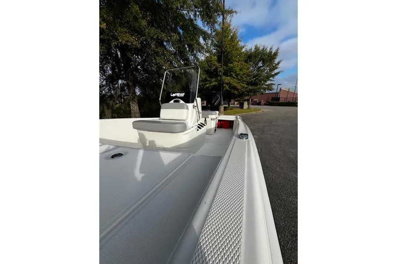 Slide: The Image of 2026 Mako Pro Skiff 15 CC boat, parked outdoors, showcasing sleek design and spacious deck. - 8