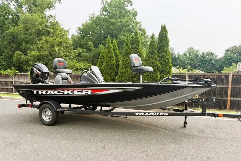 The Image of 2026 Tracker Pro Team 175 boat on trailer, parked outdoors with trees in background. - 0