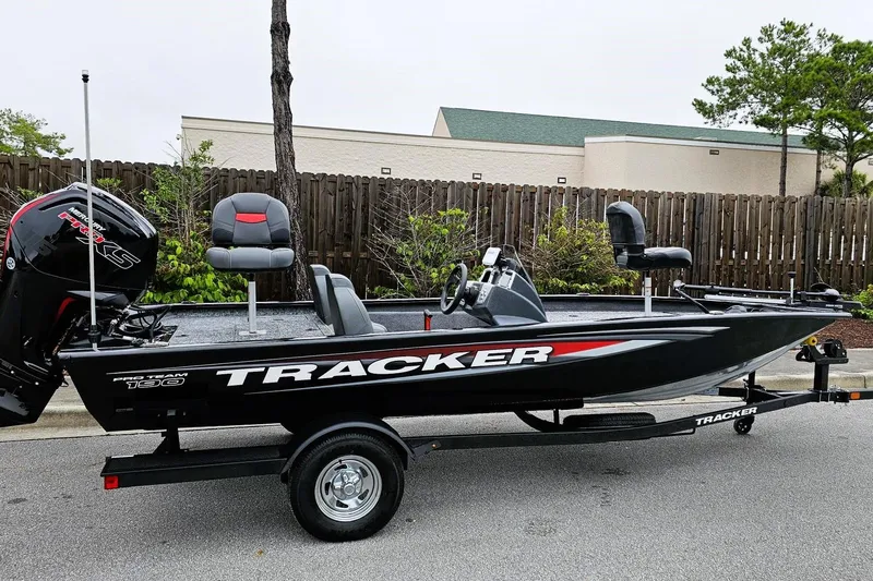 The Image of 2026 Tracker Pro Team 190 boat on trailer, black with red accents, parked outdoors. - 0