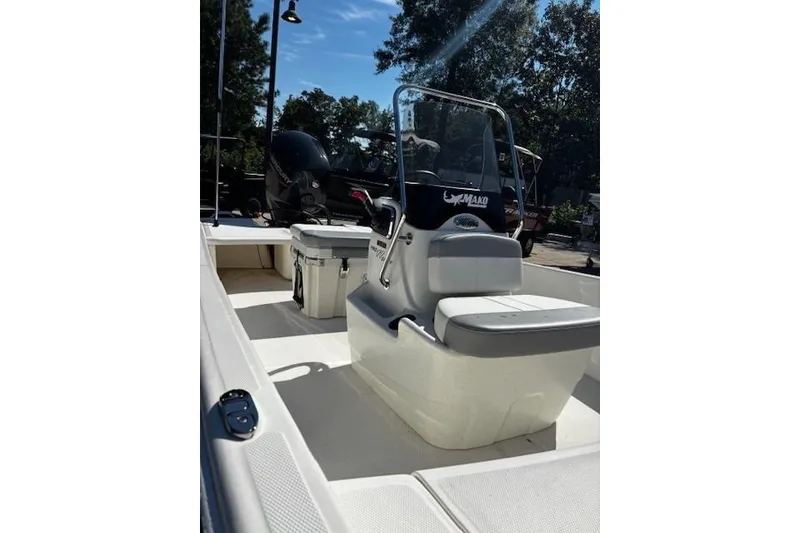 Slide: The Image of 2026 Mako Pro Skiff 17 CC boat interior with seating and console, outdoors. - 2