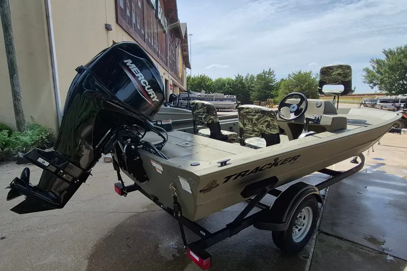 Slide: The Image of 2026 Tracker Grizzly 1754 SC boat with Mercury engine, parked outdoors on a trailer. - 4