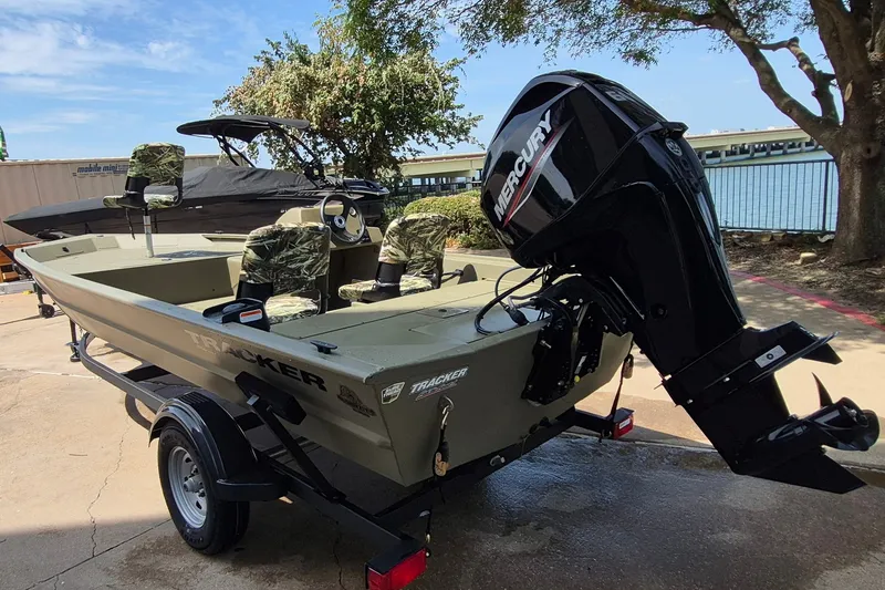 Slide: The Image of 2026 Tracker Grizzly 1754 SC boat with Mercury engine, parked outdoors. - 6