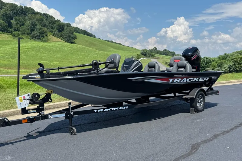 Slide: The Image of 2026 Tracker Pro Team 190 boat on trailer, parked on asphalt with scenic green hills. - 2
