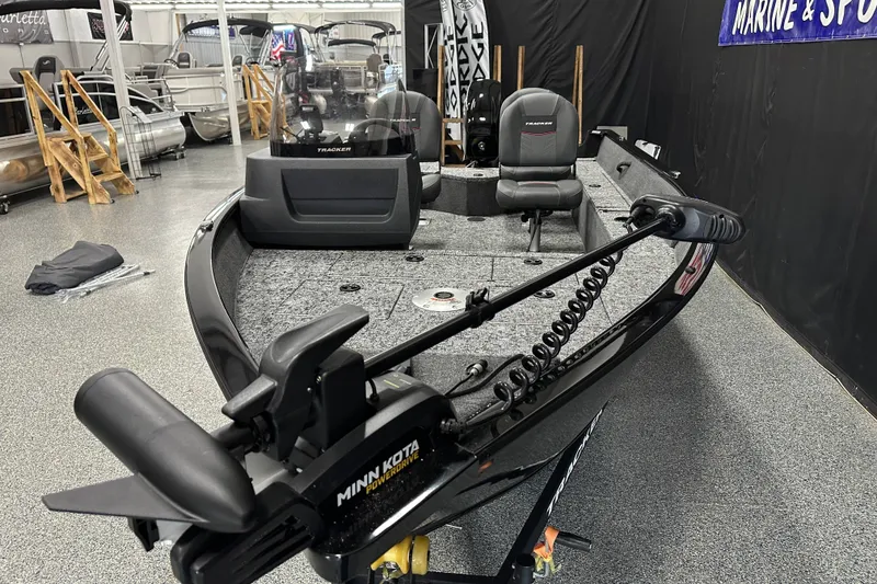 Slide: The Image of 2026 Tracker Pro Guide V-16 SC fishing boat in showroom, featuring Minn Kota trolling motor. - 10