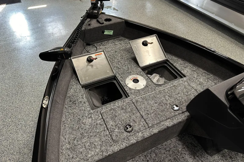 Slide: The Image of 2026 Tracker Pro Guide V-16 SC boat interior with storage compartments and trolling motor. - 13