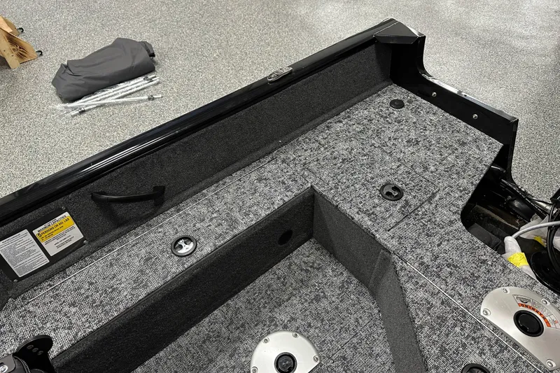 Slide: The Image of Interior view of 2026 Tracker Pro Guide V-16 SC boat with carpeted flooring. - 19