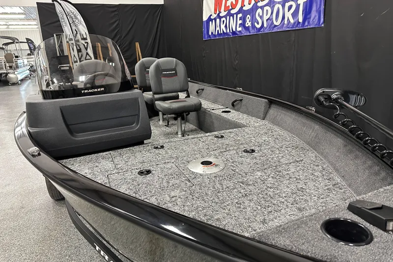 Slide: The Image of 2026 Tracker Pro Guide V-16 SC fishing boat in showroom, featuring spacious deck and seating. - 4