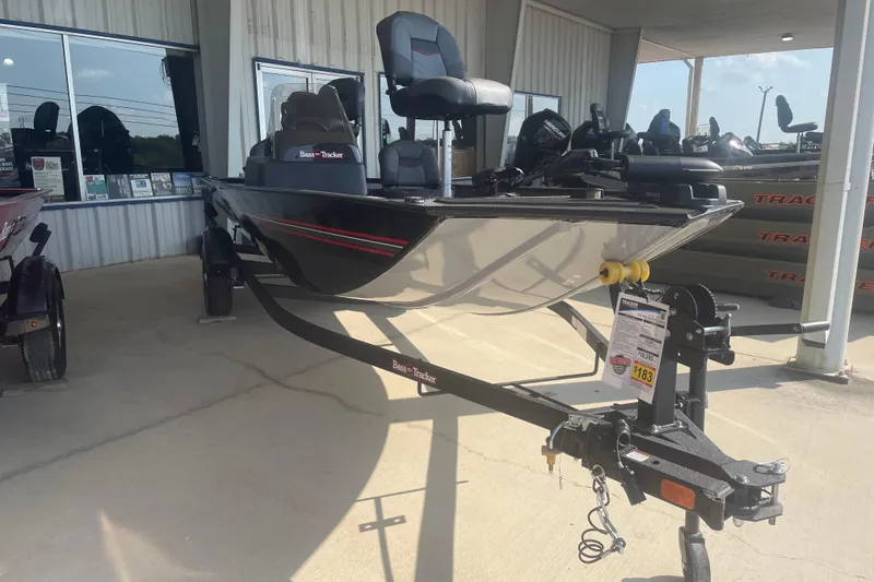 Slide: The Image of 2026 Tracker Bass Tracker Classic XL boat displayed at dealership, featuring sleek design and trailer. - 5