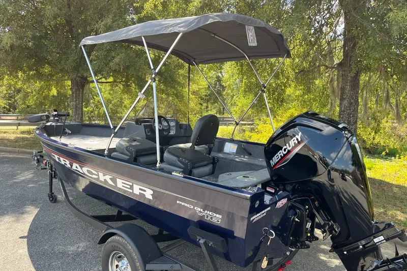 Slide: The Image of 2026 Tracker Pro Guide V-16 SC boat with Mercury engine, parked outdoors. - 3