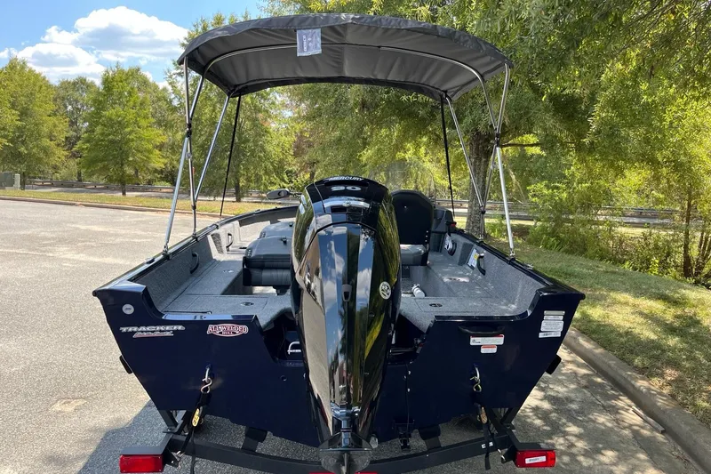 Slide: The Image of 2026 Tracker Pro Guide V-16 SC boat with canopy, parked outdoors on a sunny day. - 4