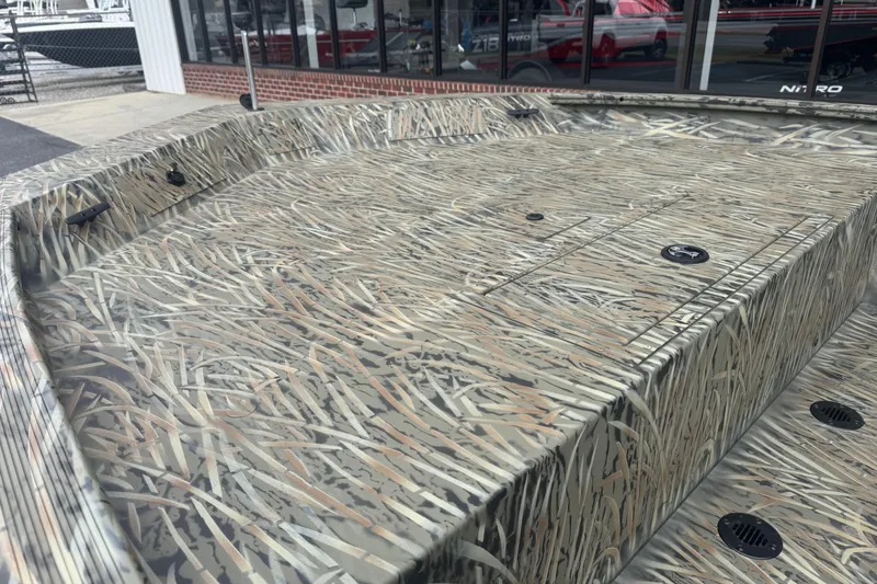 Slide: The Image of 2026 Tracker Grizzly 1860 CC boat with camouflage pattern, displayed outdoors. - 23