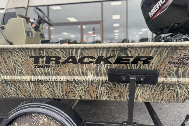 Slide: The Image of 2026 Tracker Grizzly 1860 CC boat with camo design and Mercury engine. - 3
