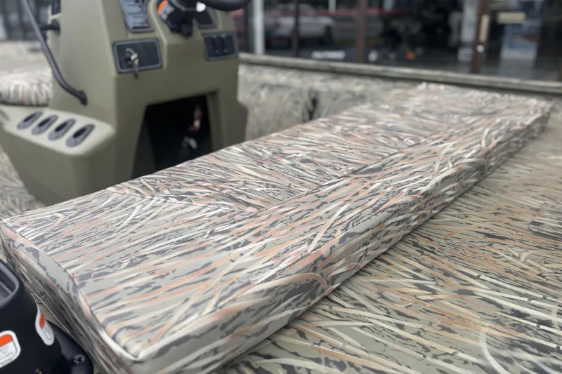 Slide: The Image of 2026 Tracker Grizzly 1860 CC boat interior with camo seating and console. - 5