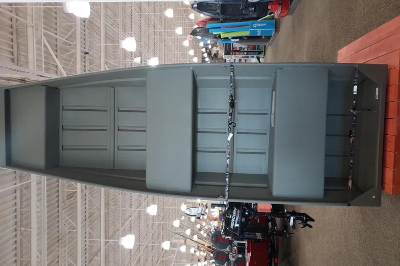 The Image of 2026 Tracker Grizzly 12 Jon boat displayed in a store with boating accessories. - 0