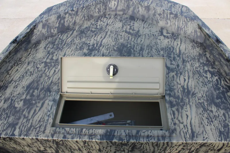 Slide: The Image of 2026 Tracker Grizzly 1754 Utility boat with open storage compartment, camo pattern. - 10