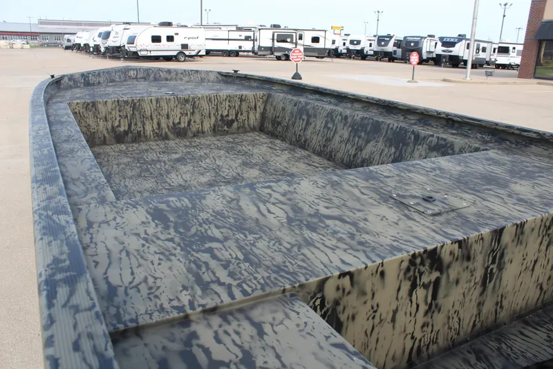 Slide: The Image of 2026 Tracker Grizzly 1754 Utility boat with camouflage design, parked near RVs. - 7