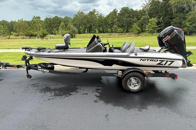 The Image of 2026 Nitro Z17 boat on trailer, parked on asphalt with green landscape background. - 0