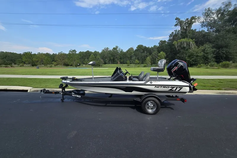 Slide: The Image of 2026 Nitro Z17 boat on trailer, parked on asphalt with lush greenery background. - 4