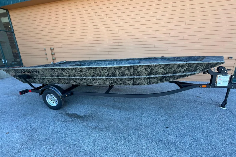 The Image of 2026 Tracker GRIZZLY 1860 Utility boat on trailer, parked outdoors. - 0